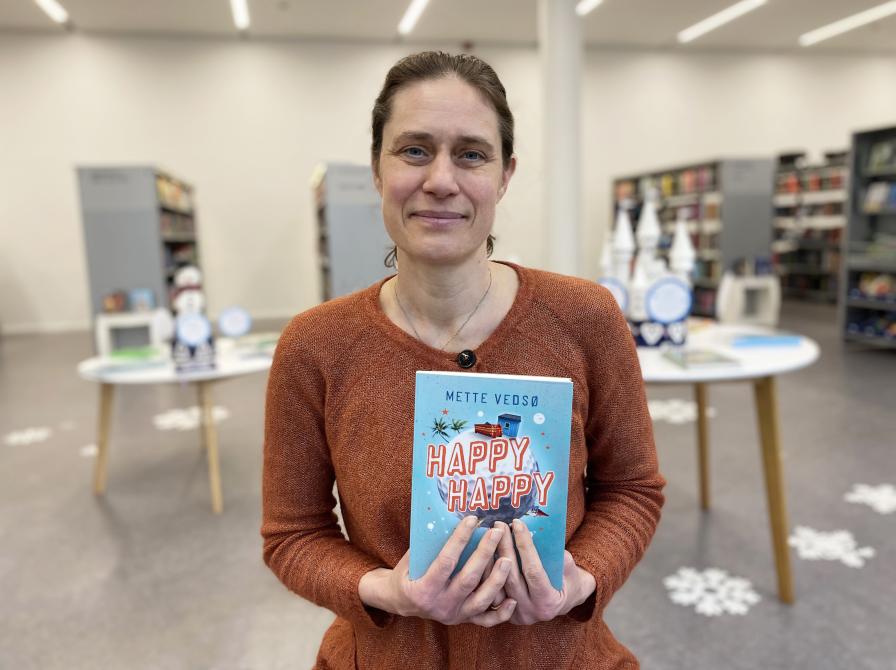 Bibliotekets børnelitteraturformidler Nicoline med Mette Vedsøs bog 'Happy Happy'