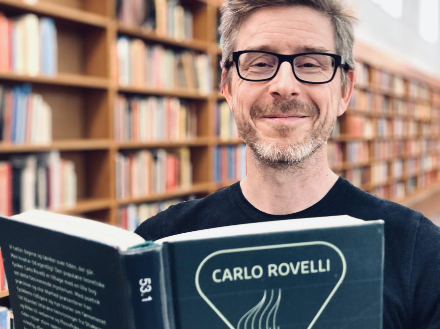 Bibliotekets litteraturformidler Håkon Bundgaard Paulsen med Carlo Rovellis bog 'Tidens orden'